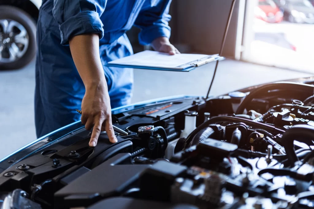 mécanicien vérifiant le moteur d'une voiture