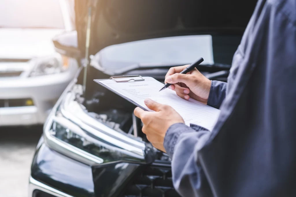 mécanicien vérifiant les points de contrôle d'une voiture sur une feuille