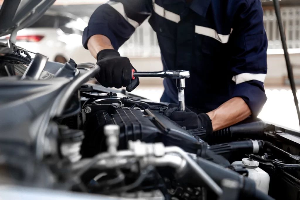 mécanicien réparant un moteur de voiture